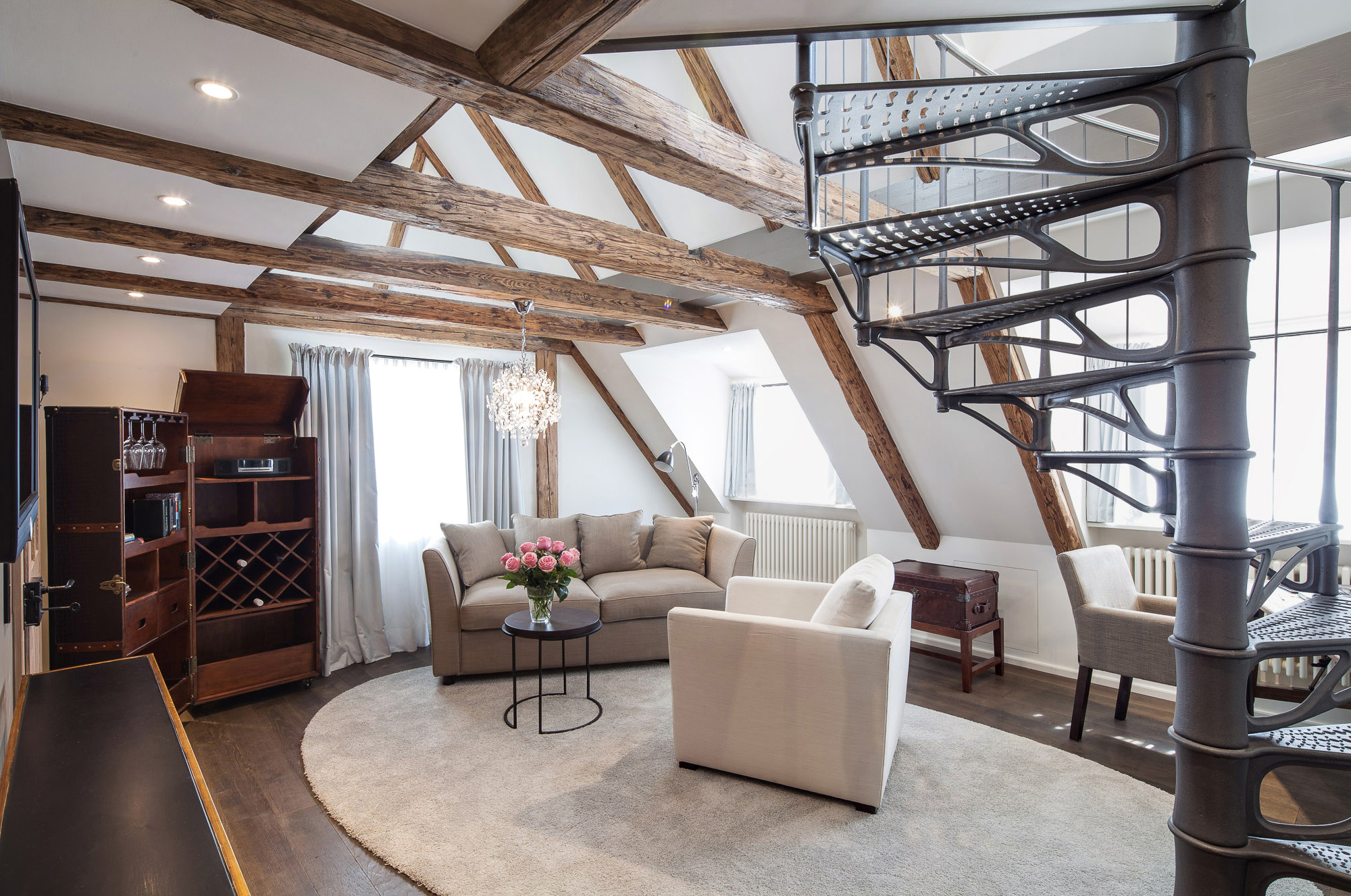 Raumblick in Top Suite N° 14 mit Wendeltreppe, Couch und Sessel